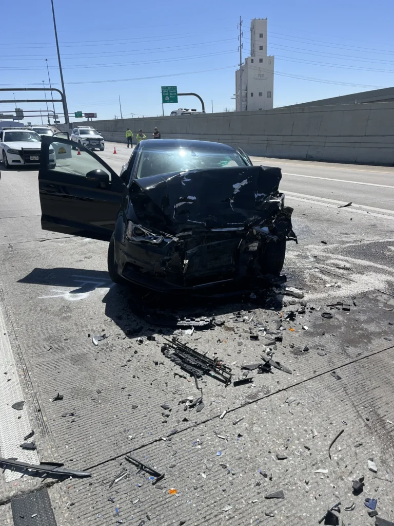 Black Audi with extensive front end damage in the middle of I-15
