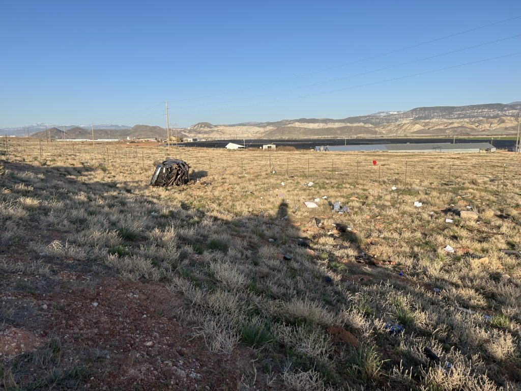 Rolled vehicle on the side of the roadway.