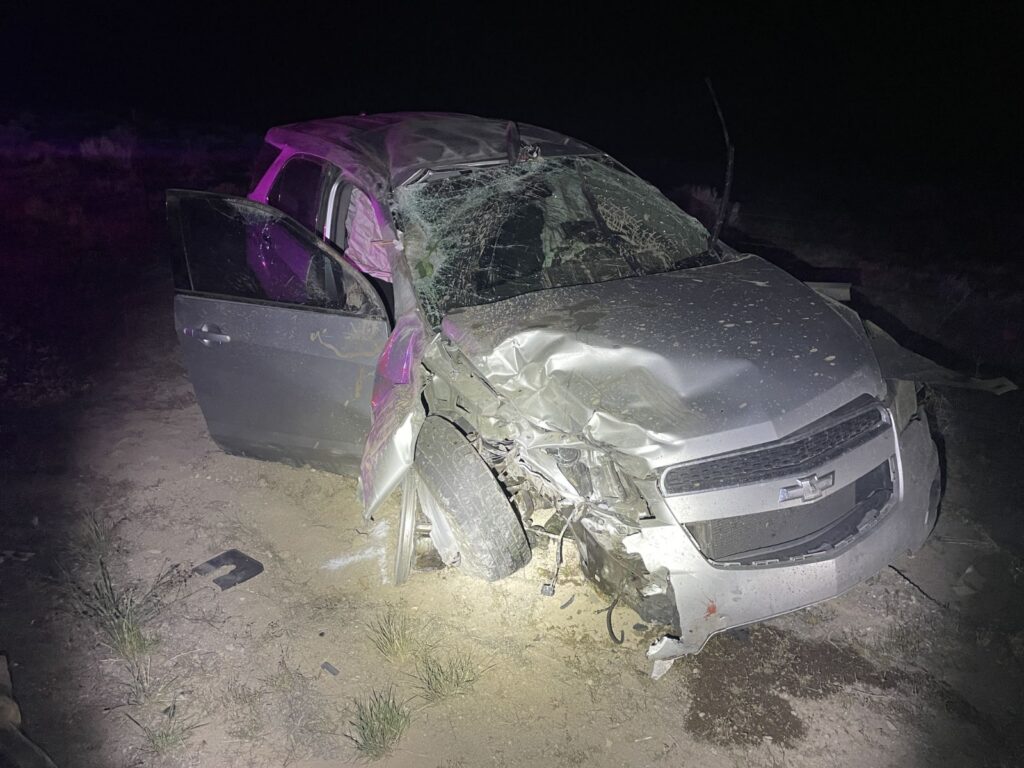 Front view of an SUV with front end damage, air bags deployed, and windshield smashed. 